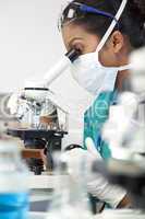 Asian Woman Doctor or Scientist Using a Microscope In Laboratory