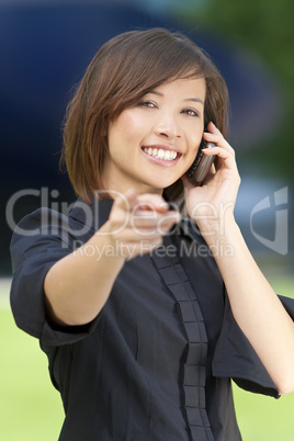 Beautiful Oriental Woman on Her Smart Cell Phone and Pointing