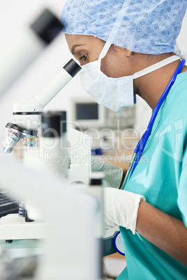 Asian Woman Doctor or Scientist Using a Microscope In Laboratory