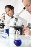 Female Scientific Research Team Using Microscopes in a Laborator