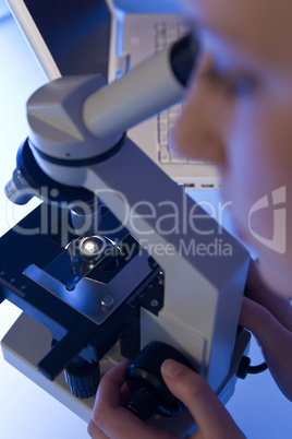 Woman Using A Microscope and Laptop In A Laboratory