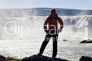 Woman Hiker Stnding In Front Of a Huge Waterfall