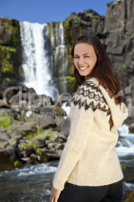 Beautiful and Happy Scandinavian Woman In Front Of A Waterfall