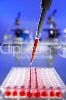 Red Solution Scientific Research With a Pipette and Cell Plate