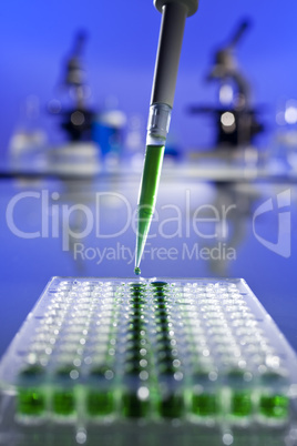 Green Solution Scientific Research With a Pipette and Cell Plate