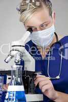 Beautiful Blond Doctor or Scientist Using Microscope In A Labora