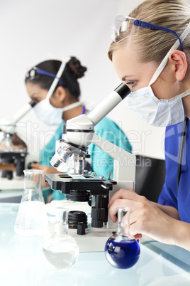 Female Scientific Research Team Using Microscopes in a Laborator