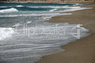 Sea waves dash on sand coast of mediterranean beach