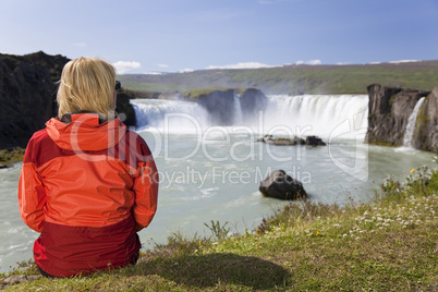 Woman Sitting At Godafoss Waterfall