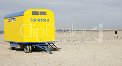 Gelber Toilettenwagen am Strand