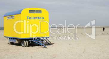 Gelber Toilettenwagen am Strand