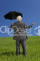 Businessman In A Green Field With Umbrella