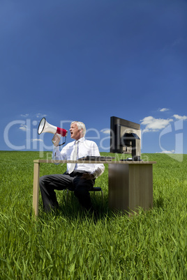 Man Using Megaphone In A Green Field