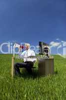 Man Using Megaphone In A Green Field