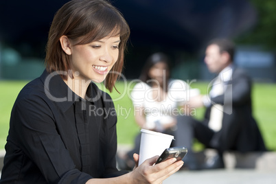 Beautiful Young Asian Woman Texting and Drinking Coffee