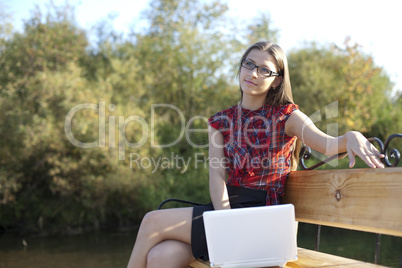Girl on bench work with laptop in autumn park