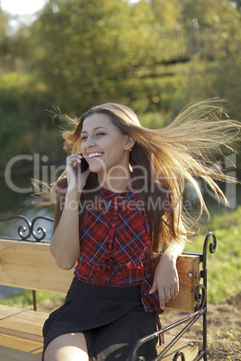 Girl on bench call phone and smile