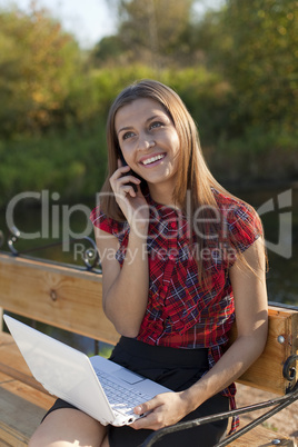 Girl on bench work with laptop and call  phone