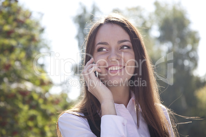 Girl call  phone and smile in autumn park