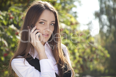 Girl  call  phone and smile in autumn park