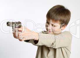 Child with gun on light background