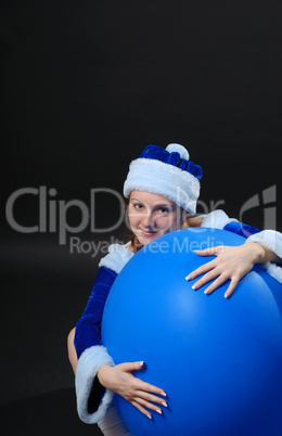 Weihnachtsfrau mit einem großen blauen Luftballon.