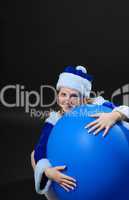 Weihnachtsfrau mit einem großen blauen Luftballon.