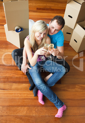 Happy couple celebrating new apartment with champagne