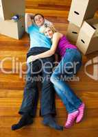 Happy couple relaxing on the floor. Moving house