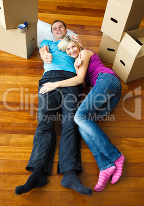 Couple lying on the floor with thumbs up. Moving house