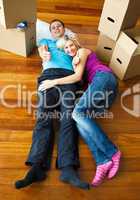 Couple lying on the floor with thumbs up. Moving house