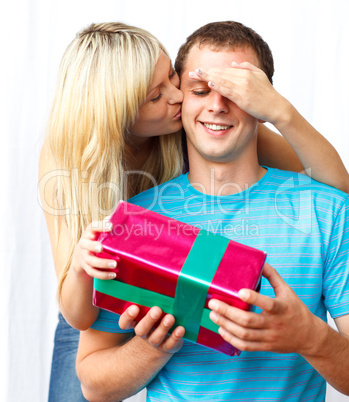 Woman giving a present and a kiss to a man