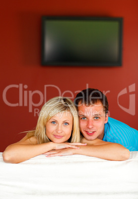 Couple sitting on couch with television in the background