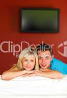 Couple sitting on couch with television in the background