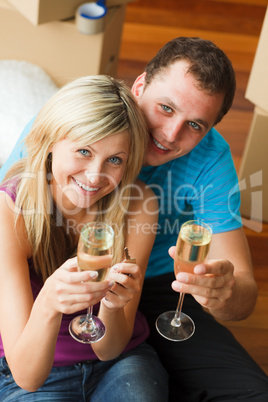 High angle of a happy couple celebrating new house with champagn