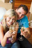 High angle of a happy couple celebrating new house with champagn