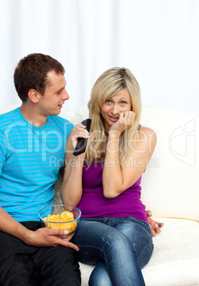 Couple watching television together on sofa