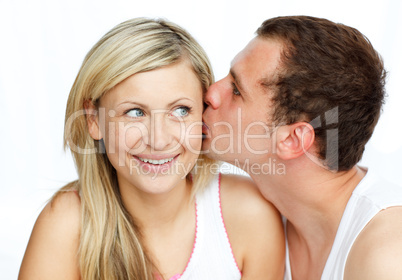 Junger Mann küsst eine Frau auf die Wange