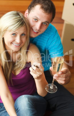 Happy couple celebrating new house with champagne