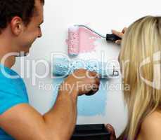 Couple painting new house with two colours.