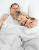 Junges Paar liegt aneinandergekuschelt im Bett