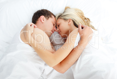 Junges Paar schläft Arm in Arm im Bett