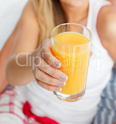 Ein Glas Orangensaft in einer Frauenhand