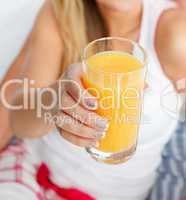 Ein Glas Orangensaft in einer Frauenhand
