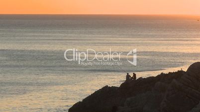 Couple of fishermen fishing at sunset