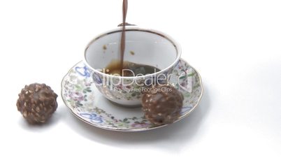 Cup of coffee pouring with chocolate candies