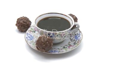 Cup of coffee rotating with chocolate candies