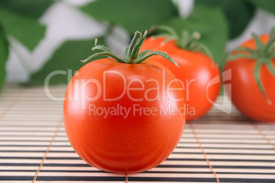 Three tomatoes on bamboo napkin