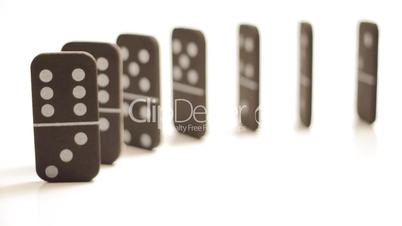 Stacked dominoes tipping over isolated on white