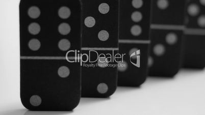 Closeup and pan of black dominoes isolated on white
